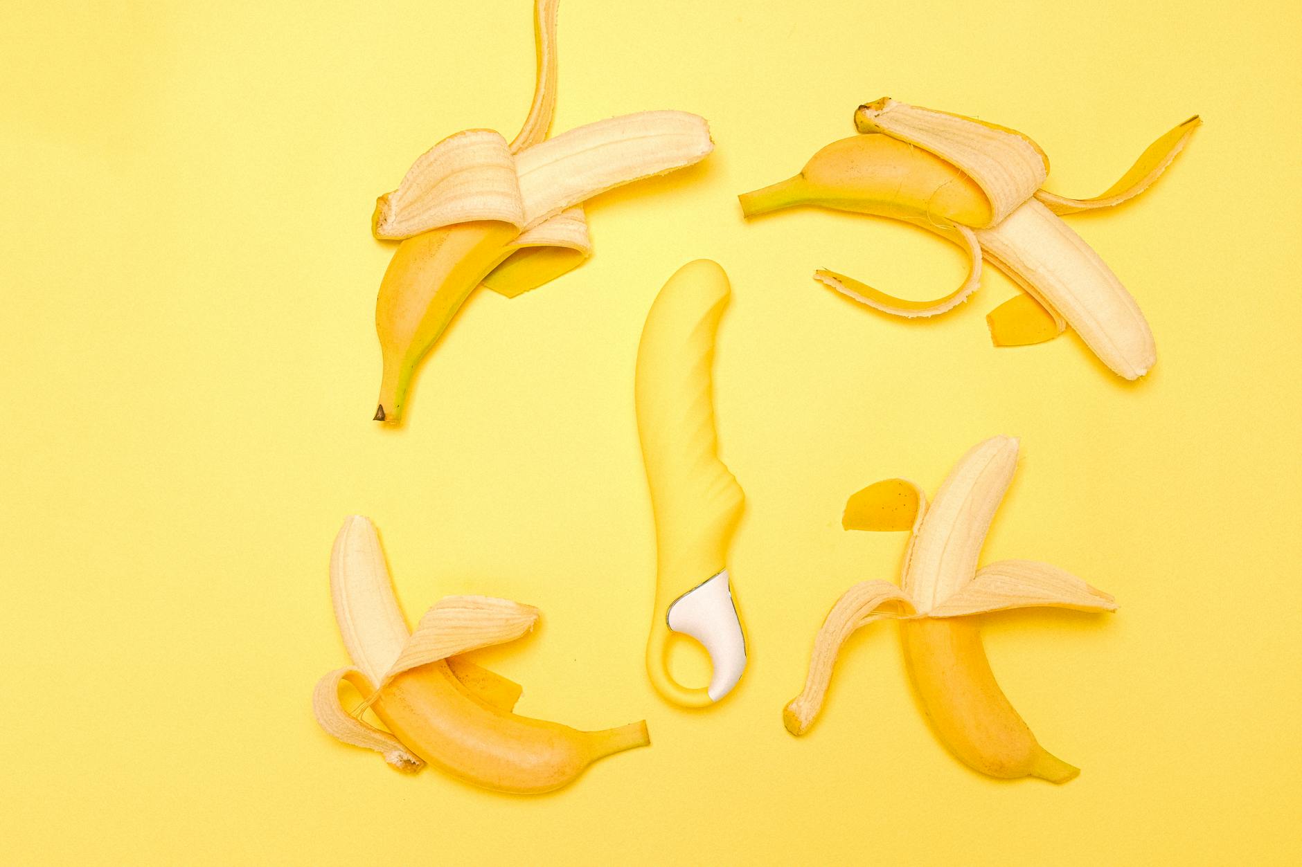 A yellow lemon vibrator surrounded by fresh lemons on a bright background, symbolizing revival and renewal of pleasure.