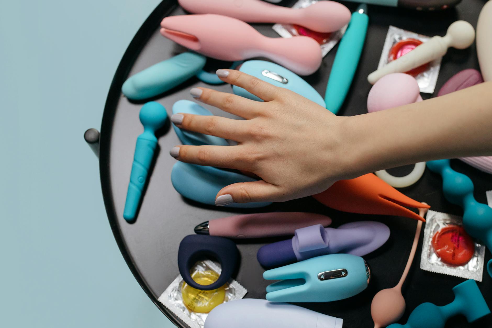 Colorful vibrators and intimate wellness products arranged on a bright yellow background