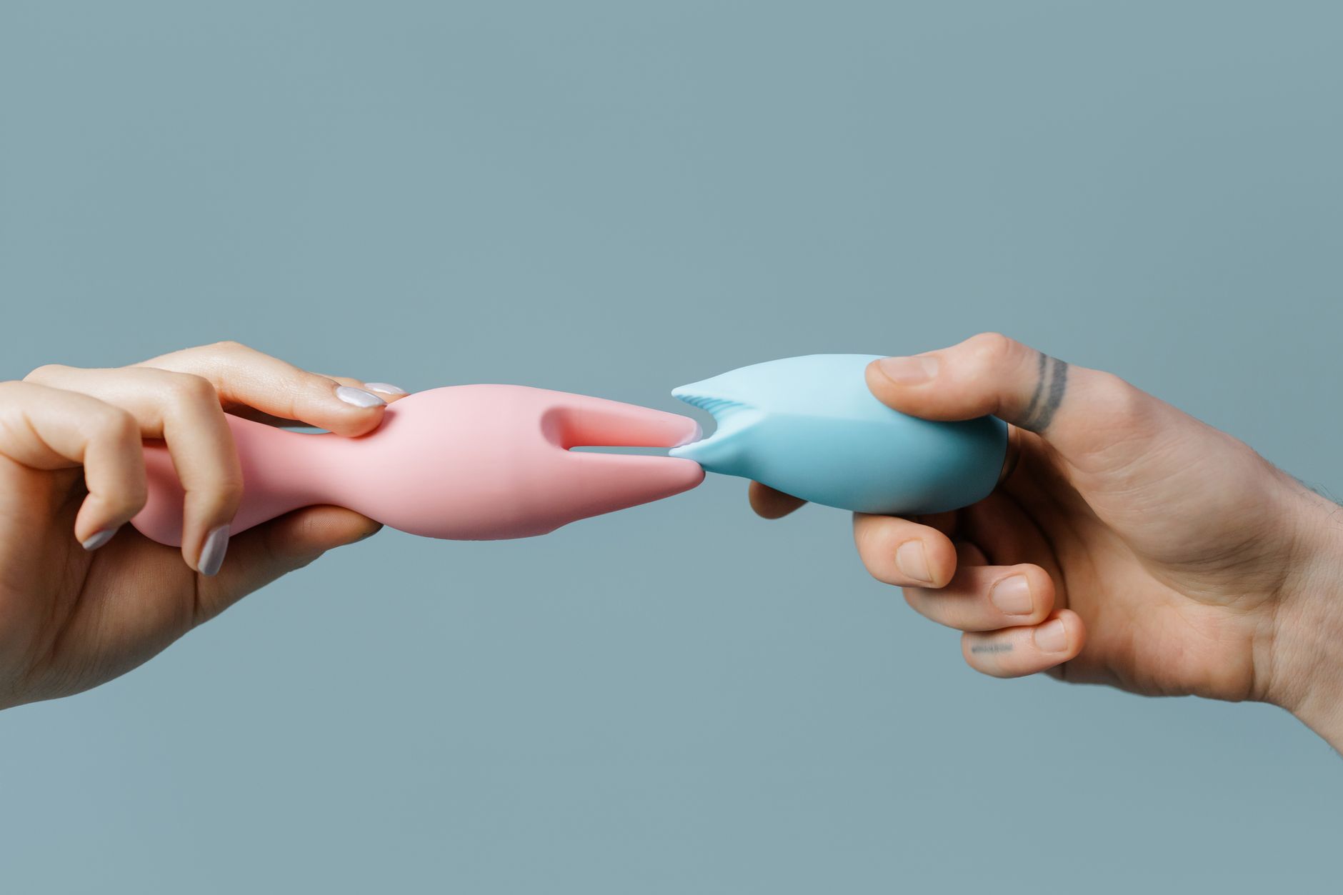 Mulheres segurando vibradores coloridos de silicone, representando intimidade e empoderamento
