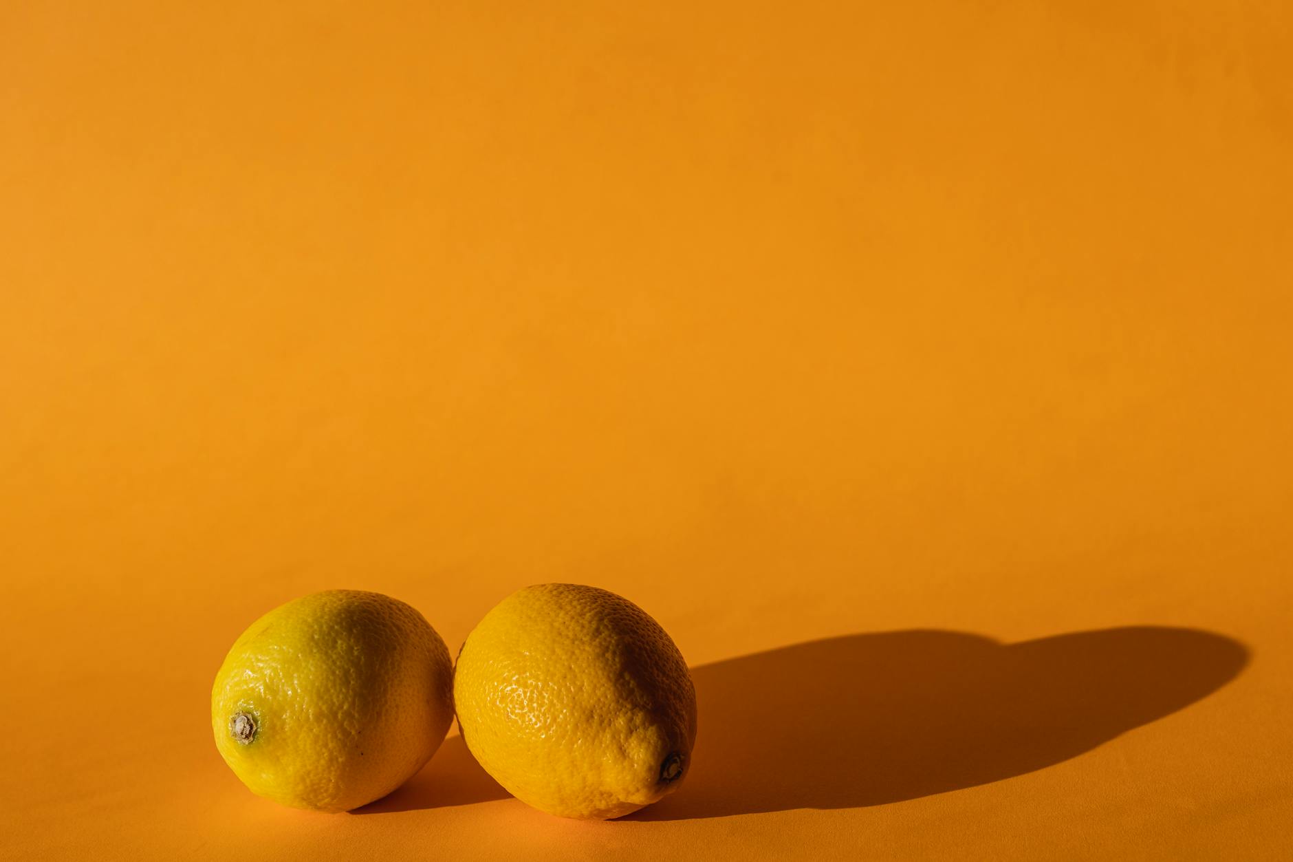 Ripe lemons on a bright yellow background, representing refreshed pleasure strategies